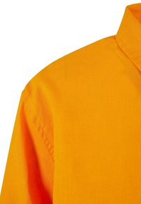 Orange bomulls skjorta med axlar, med en strukturerad krage och slät textur, med synlig söm längs sömmarna.