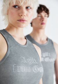 Gray ribbed tank tops with silver rhinestone text reading "A gift from God," featuring a fitted design and classic neckline.