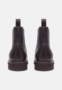 Bottines en cuir marron avec une finition texturée, dos droit, languette de tirage et semelle en caoutchouc robuste.