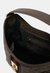 Borsa a tracolla marrone con texture, manico in pelle liscia, interni in tessuto nero, tasca con zip e dettagli in hardware color oro.