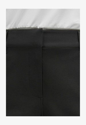 Czarne spodnie o gładkiej fakturze i płaskim pasie. Posiadają przeszycia w szwach oraz tylne kieszenie, cechują się czystym, minimalistycznym designem.