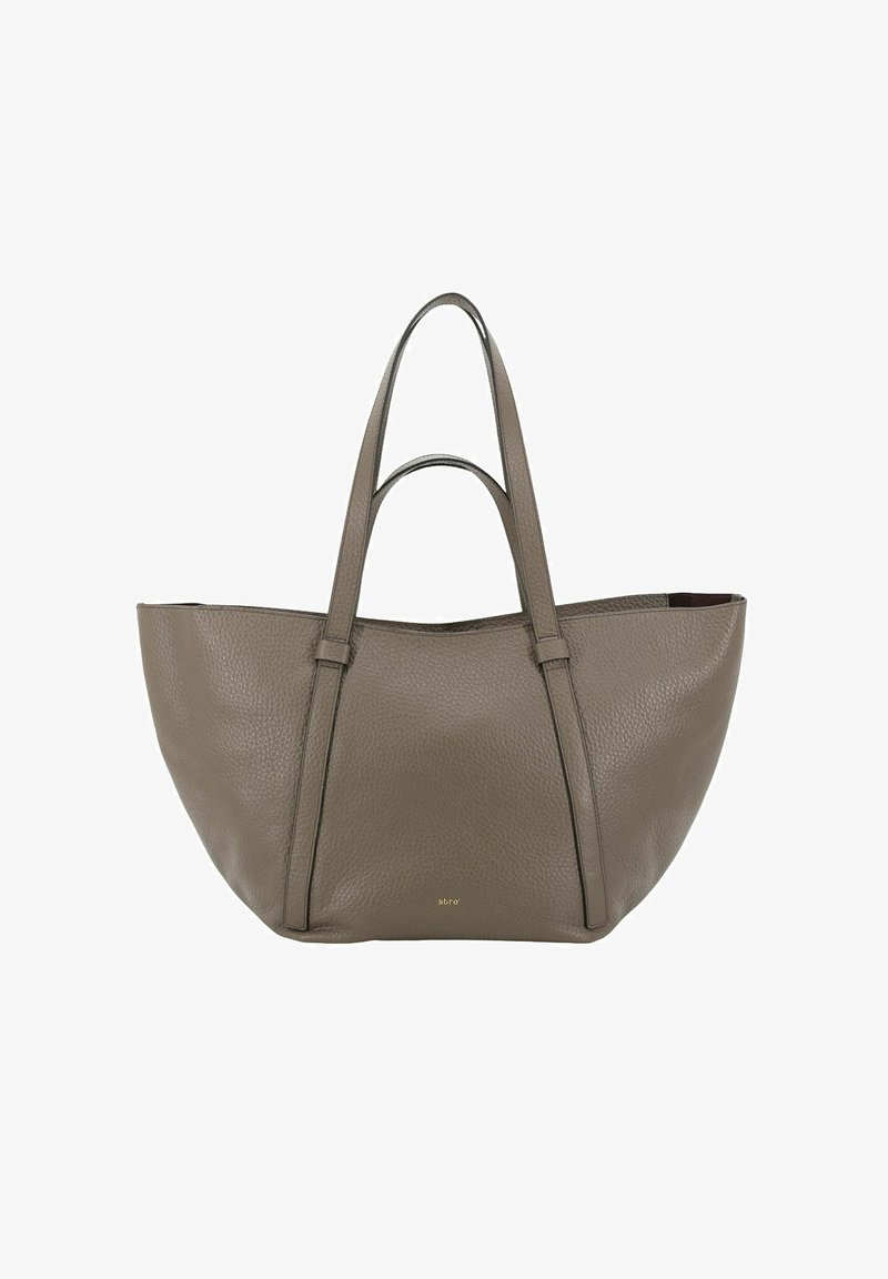 Sac fourre-tout en cuir taupe à grain, avec deux poignées supérieures, forme trapézoïdale structurée et logo doré discret près du centre de la base.