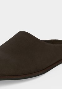 Chaussure en daim marron foncé à enfiler avec bout pointu et petit talon, présentée sur fond blanc.