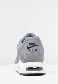 Nike Air-sneaker i grå mocka med meshdetaljer, som har en vit mellansula och svart yttersula, med logotypdetalj på hälen.