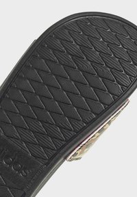 Semelle de sandale à glissière en caoutchouc noir avec un motif en relief en diamant, dotée d'une sangle en tissu camouflage avec un bord contrastant.
