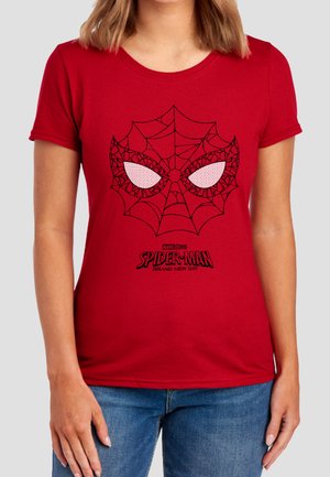 Frau trägt ein rotes T-Shirt mit einem schwarzen Spider-Man-Netzmuster und Augendesign sowie dem Text "Marvel Studios Spider-Man Brand New Day" darunter.