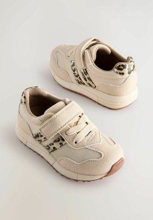 Beige sportssko med en tekstureret overdel, en velcrolukning og leopardprint-detaljer på siderne og hælen. Gummisål for godt greb.