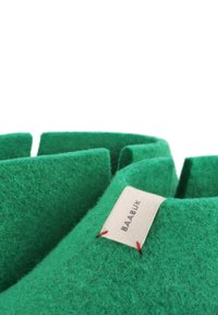 Zelené plstěné pantofle se strukturovaným designem, s texturovaným povrchem, štítkem a červenými švy.