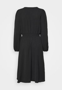 Vestido preto de manga longa com cintura franzida, decote redondo e saia fluida, apresentando uma textura suave e sem padrões ou acentos visíveis.