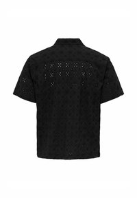 Črna kratkosleeve majica z vezenim oblikovanjem, ki vsebuje diamantske vzorce in izrezane detajle na hrbtu in ramionih.