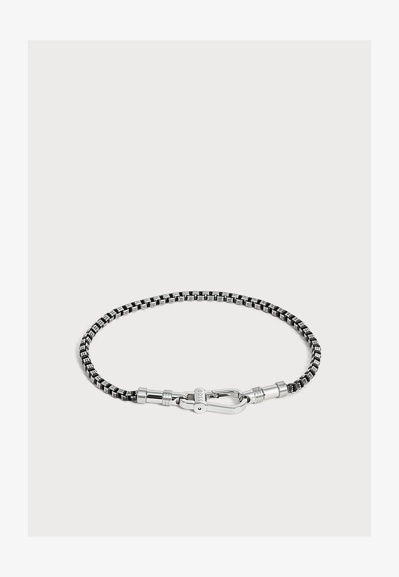 Bracelet tressé noir et argent avec une fermeture en métal argenté gravée de "BOSS" sur un fond clair uni.