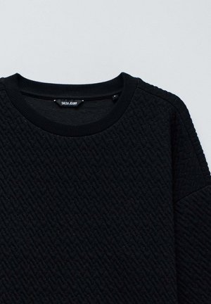 Schwarzer strukturierter Pullover mit einem Diamantmuster, geripptem Rundhalsausschnitt und subtiler glänzender Oberfläche. Markenlabel "Salsa Jeans" innen sichtbar.