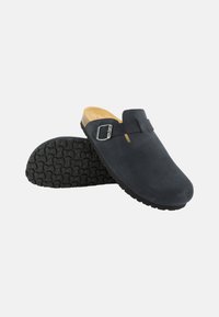 Schwarze Wildleder-Clogs mit einer Metall-Schnalle, runder Zehenpartie und strukturierter Gummi-Außensohle. Mit einer hellbraunen gepolsterten Innensohle.