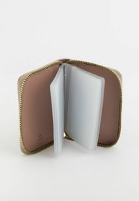 Cartera de tarjetas con cremallera en color beige con herrajes dorados. En el interior cuenta con un forro marrón suave y compartimentos de plástico transparente para un almacenamiento seguro.