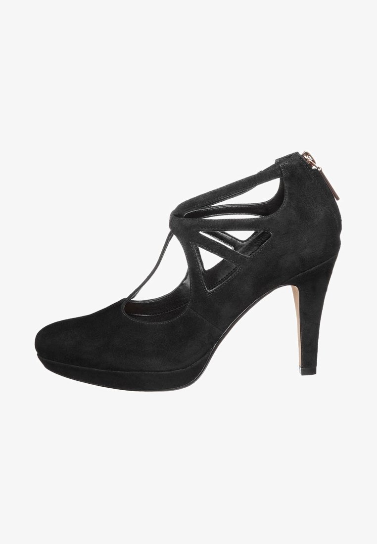 Černá semišová vysoká podpatková bota s vyřezávaným designem a zadním zipem. Obsahuje zaoblenou špičku a štíhlý podpatek pro zvýšení.