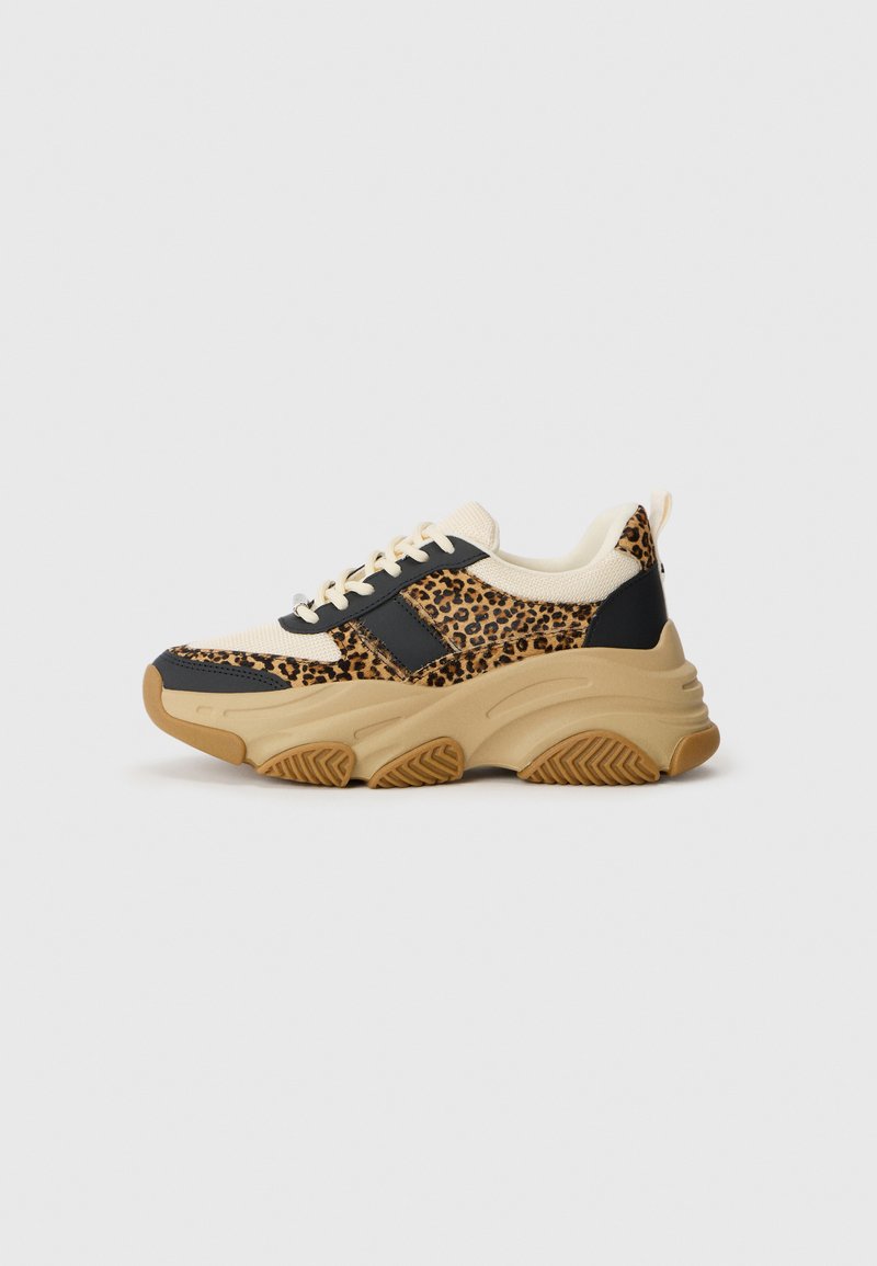 Luipaardprint sneaker met een beige gebreide bovenkant, zwarte leren accenten en een dikke gumrubberen zool met een gestructureerd loopvlak.