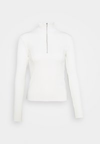 Witte geribbelde top met lange mouwen, een hoge hals en een centrale zilveren rits. Getailleerd ontwerp, gladde textuur en subtiel verticaal patroon.