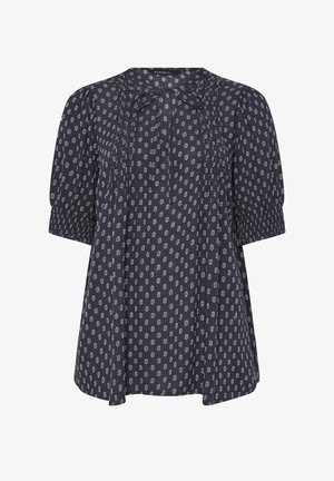 Blouse bleu marine à motif floral blanc, manches courtes bouffantes, poignets smockés, plis sur le devant et petit nœud à l'encolure ronde.