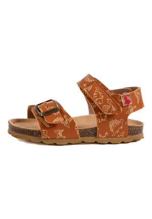 Sandales brunes pour tout-petits avec motifs de dinosaures, fabriquées en matériau synthétique. Elles disposent d'une sangle réglable, d'une semelle en liège et d'un lit de pied texturé.