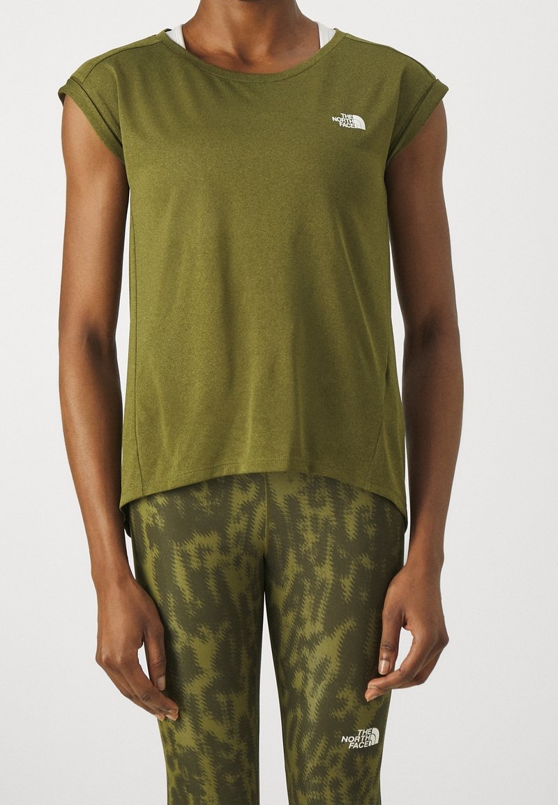 Olivgrön sporttröja, kort ärm, rund halsringning, gjord av mjukt tyg. Har en liten vit logotyp på bröstet. Matchas med mönstrade leggings.