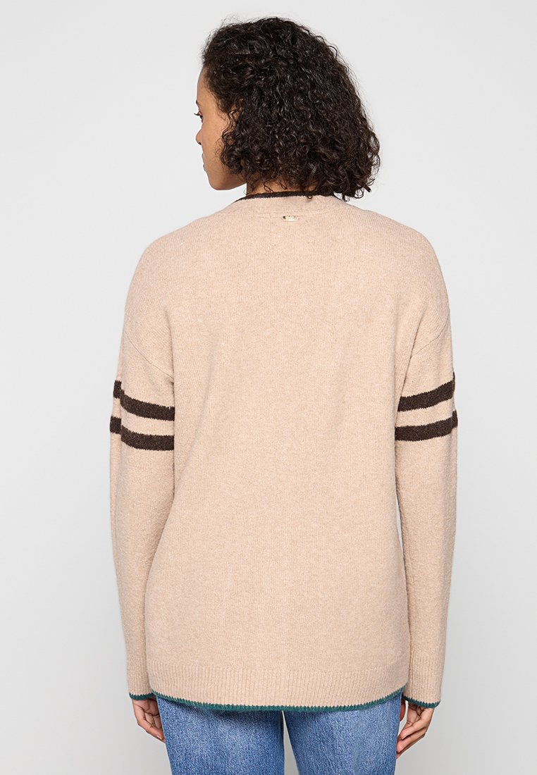Beżowy sweter dzianinowy o luźnym kroju, z brązowymi paskami na rękawach i zielonym wykończeniem. Miękka tekstura, okrągły dekolt i rękawy o długości trzech czwartych.