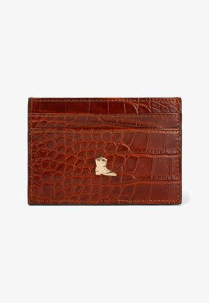 Brown crocodile leather cardholder with four card slots, featuring a gold boot logo accent and contrasting stitching details.