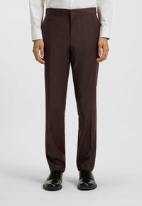 Burgundy trousers with a textured finish, featuring a straight cut, belt loops, and side pockets, paired with black shoes.