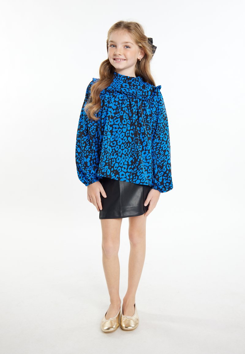 Blå og sort leopardprint skjorte med flæsekrave, parret med en sort lædernederdel og gyldne balletflat shoes.
