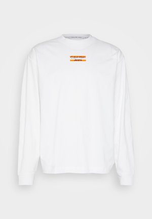 Biela dlhá blúzka s dlhým rukávom vyrobená z bavlny, s okrúhlym výstrihom, na strede s oranžovým a čiernym logom "Calvin Klein Jeans".