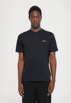 Black short-sleeve t-shirt with a v-neck design, featuring a small multicolored striped detail on the left chest area.