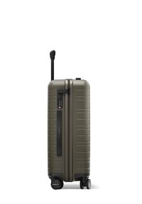 Valise rigide vert olive avec une poignée rétractable, un verrou à combinaison, des lignes texturées et quatre roues pour la mobilité.