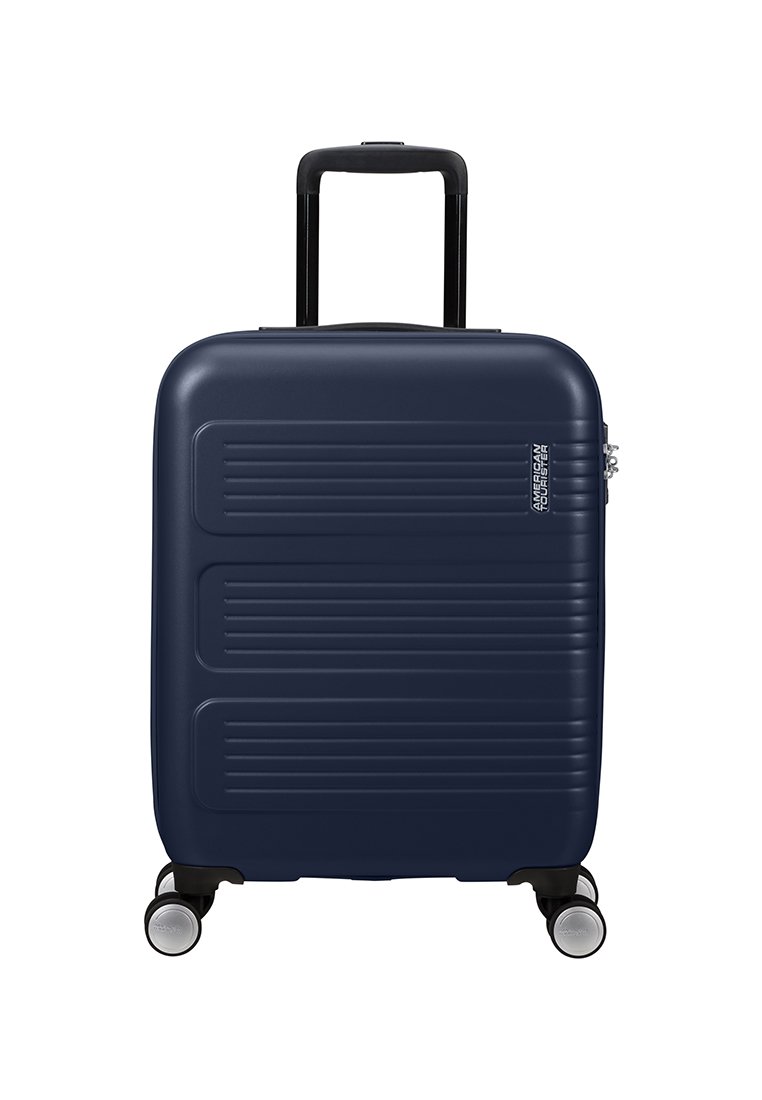 Valigia rigida blu con righe orizzontali, manico retrattile nero, quattro ruote piroettanti e lucchetto a combinazione.