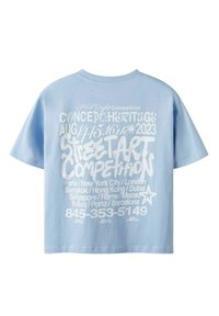 Hellblaues Baumwoll-T-Shirt mit weißen grafischen Texten, einschließlich Veranstaltungsdetails und Städtenamen, auf der Rückseite. Kurzärmelig, lockere Passform.