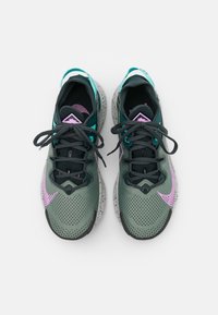 Chaussures de sport légères en gris foncé et bleu sarcelle avec une tige texturée, des accents roses et un design de semelle tachetée. Lacées avec des lacets plats gris.