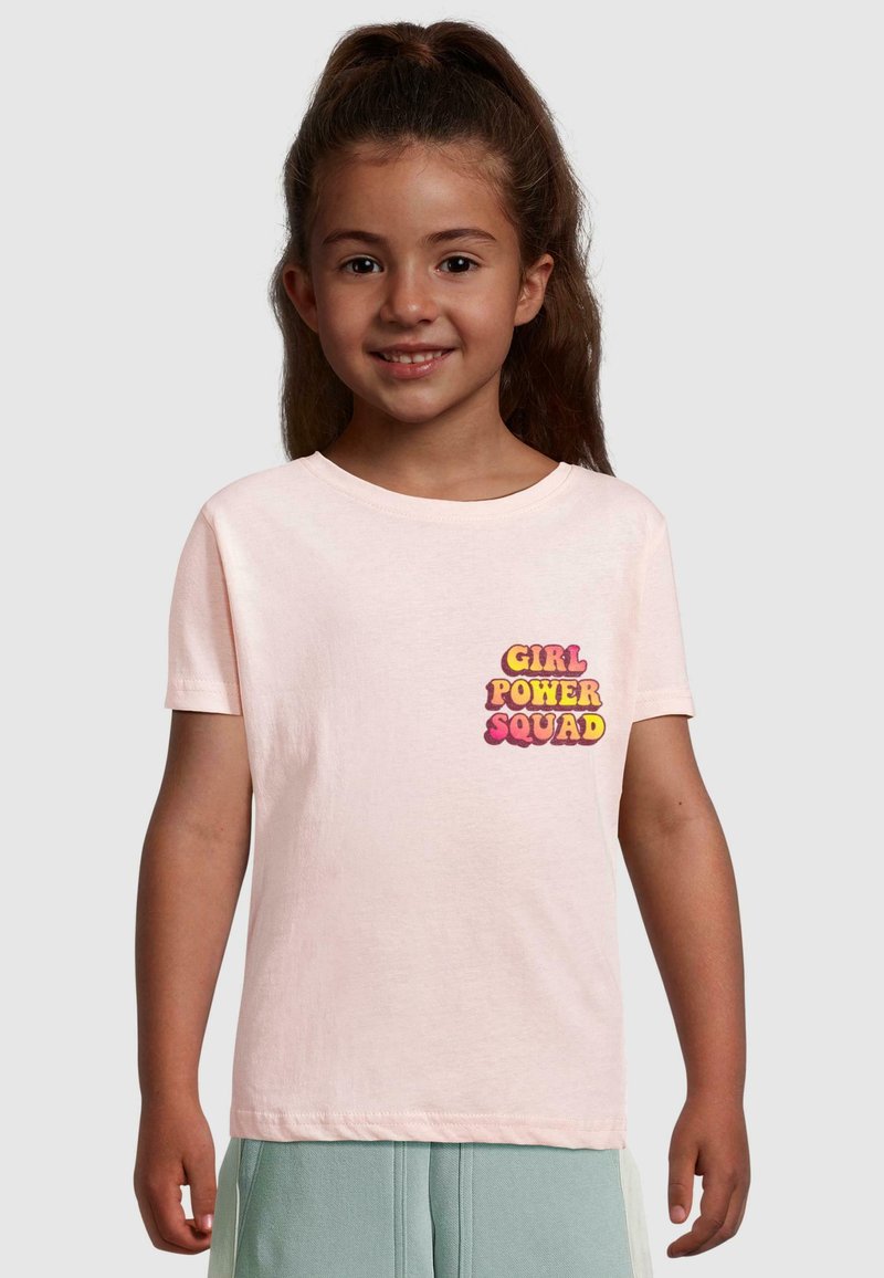Lichtroze katoenen T-shirt met de tekst "GIRL POWER SQUAD" in vetgedrukte, multiculturele letters aan de linkerkant van de borst. Korte mouwen, ronde hals.