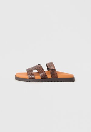 Sandales à glissière avec un motif de peau de serpent brun, deux larges sangles, semelle intérieure orange et semelle en caoutchouc texturé brun.