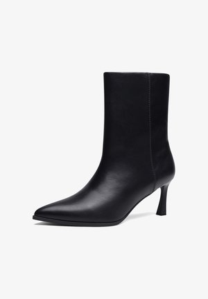 Juodos odos vidutinio ilgio batų aulai su siauru kulnu ir matomu šoniniu siuvimu, pasukti į kairę, baltame fone.