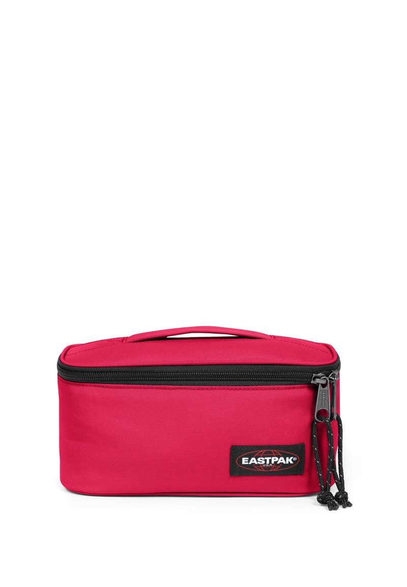 Bolsa de viaje rectangular roja hecha de tela duradera, con cierre de cremallera, asa superior y una etiqueta de marca visible en la parte frontal.