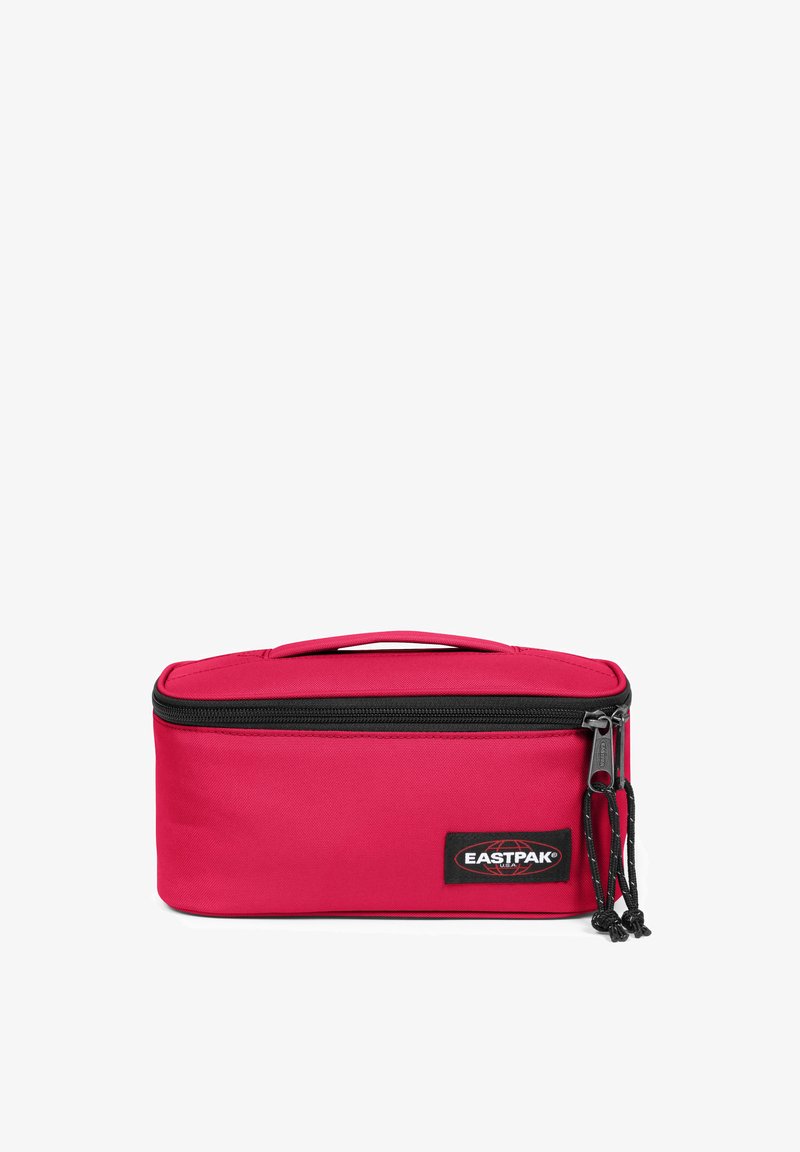 Bolsa de viaje rectangular roja hecha de tela duradera, con cierre de cremallera, asa superior y una etiqueta de marca visible en la parte frontal.