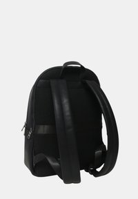Mochila negra con un acabado texturizado, forma redondeada, respaldo acolchado y correas ajustables. Presenta cremalleras lisas y detalles de malla.