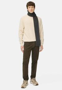 Beige ribbed sweater with a dark grey scarf, brown corduroy pants, and light beige sneakers with darker accents. Simple, modern design.