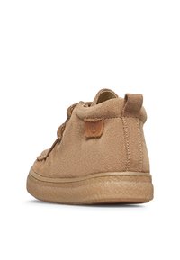 Scarpa casual in suede marrone chiaro con suola in gomma testurizzata, lacci rotondi e piccola etichetta in pelle sul lato, vista da dietro.