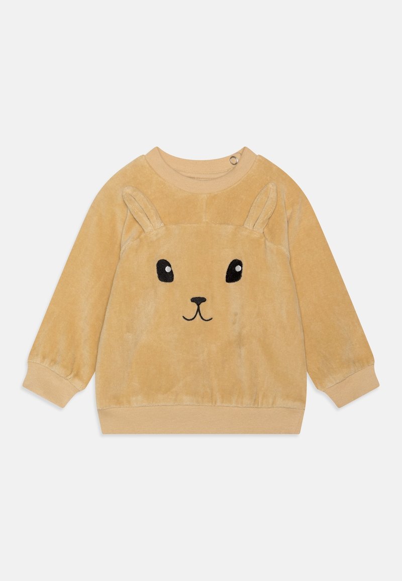 Sweatshirt en velours beige à manches longues, avec un motif de visage de lapin, des yeux noirs proéminents, et des oreilles relevées sur les épaules.