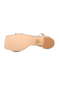 Sandali con tacco alto a punta quadrata, cinturini metallici dorati e una suola beige liscia con motivi antiscivolo.