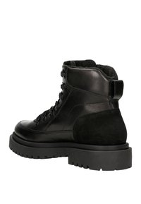 Stivaletti neri in pelle con dettagli in scamosciato, dotati di una suola in gomma spessa, design con lacci e rivestimento morbido per un comfort aggiuntivo.