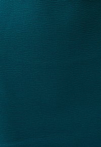 Teal textured fabric with a wavy pattern, soft and matte finish, featuring subtle variations in depth and surface detail.