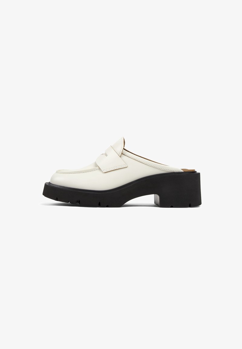 Witte leren instap loafer met dikke zwarte platformzool en lage blokhiel, zijaanzicht op een witte achtergrond.