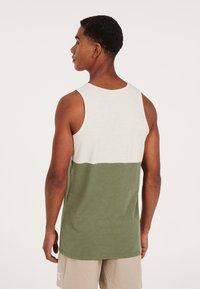 Green and white sleeveless tank top with a two-tone design. Soft fabric, relaxed fit, and a rounded neckline.