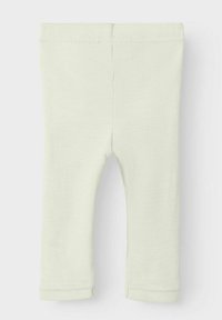 Leggings para bebé de color crema, acanaladas, con cinturilla elástica y dobladillos cosidos, sobre fondo blanco liso.