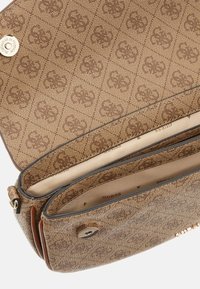 Bruine schoudertas met patroon, gemaakt van textuurmateriaal, met drukknoopsluiting, meerdere vakken en een interieur met logoprint.